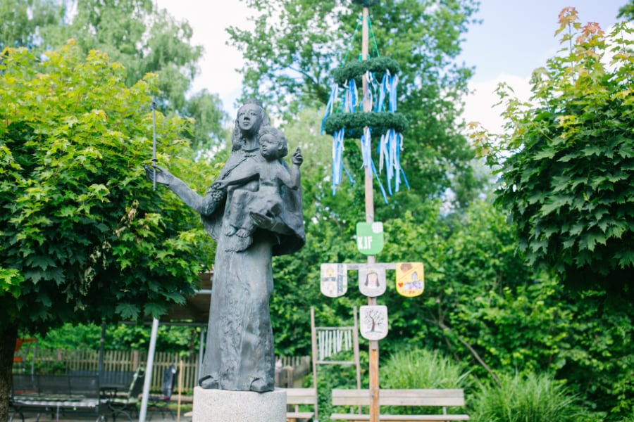 Statue von St. Hildegard mit einem Kind am Arm im Garten